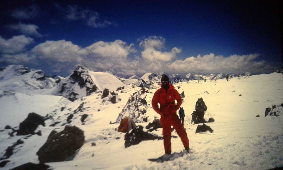 Andinista frente a un extenso paisaje nevado de alta montaña